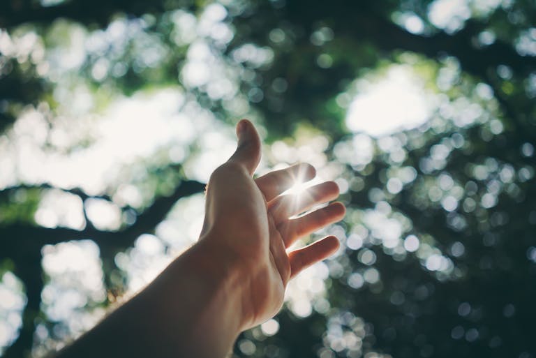 A hand reaching towards the sky, offering to help exhausted parents